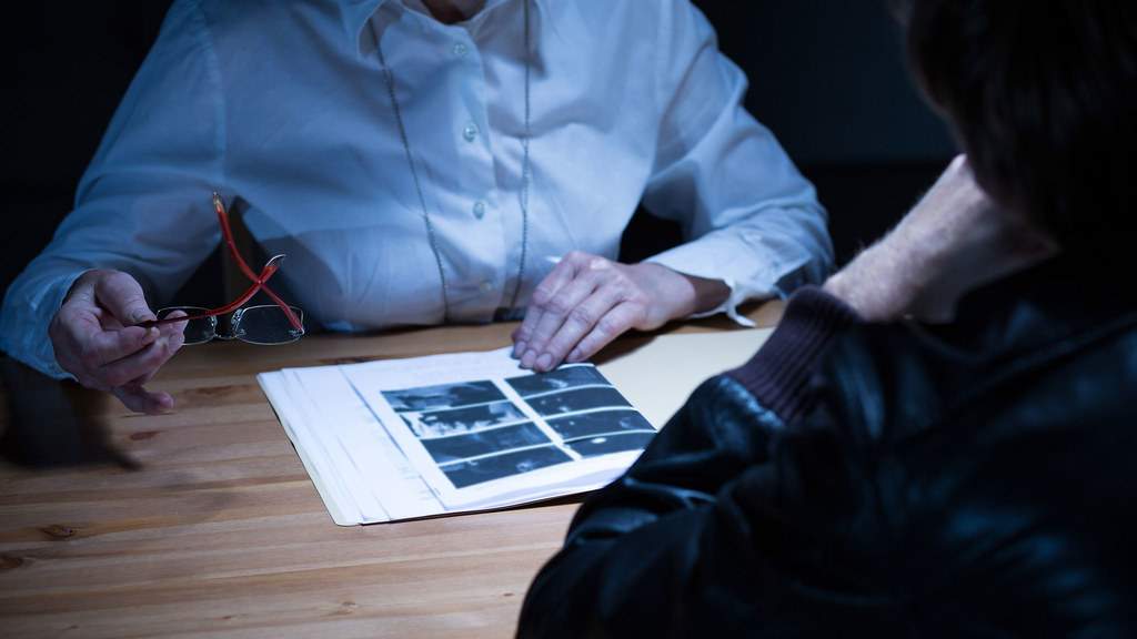 A clinician and another person review photographs together at a table.